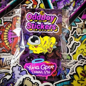 Peut inclure: Une épingle en émail jaune et bleue avec un personnage de dessin animé avec un œil et une auréole. L'épingle est entourée d'autres autocollants et du texte "Odd Boy Stickers" et "Yling Goop Enamel Pin".