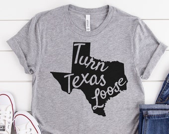 May include: A gray t-shirt with a black outline of the state of Texas and the text "Turn Texas Loose".