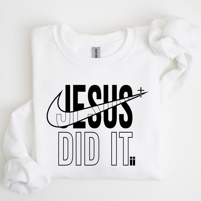 A white t-shirt with a graphic design featuring the text "JESUS DID IT" and a Nike swoosh logo.
