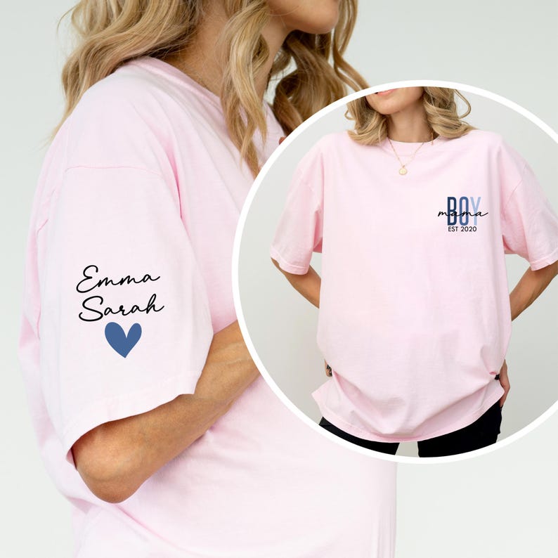 A woman wearing a pink t-shirt with a name and year printed on it, and a heart symbol.