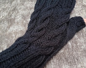 May include: A black fingerless glove featuring a textured cable knit pattern that extends from the wrist to the knuckles. The knit design includes vertical columns of twisted stitches, providing a detailed and uniform appearance throughout the fabric.