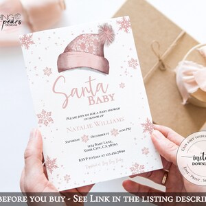 Op de afbeelding: Roze en witte babyborrel uitnodiging met sneeuwvlokken en glitter. De uitnodiging luidt "Santa Baby" en bevat de tekst "Kom gezellig langs voor een babyborrel ter ere van Natalie Williams".