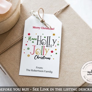 May include: A white gift tag with red, green, and gold lettering that reads "Merry Christmas! Have a Holly Jolly Christmas." The tag also includes a space for a name and the words "From: The Robertson Family".