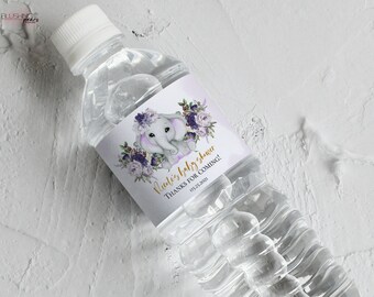 May include: A clear plastic water bottle with a purple, white, and gold label featuring an elephant illustration and the text "It's a baby shower! Thanks for coming! 01.23.2021".