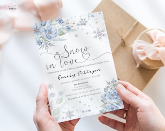 Könnte beinhalten: Eine weiße Brautduscheinladung mit einem blauen und weißen Aquarell-Blumendesign. Die Einladung lautet "Snow in love" und enthält den Namen der Braut, Emily Peterson, das Datum und die Uhrzeit der Dusche sowie den Ort.