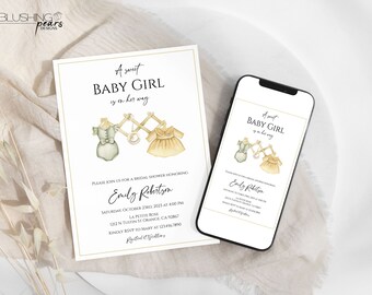 May include: A white card with gold trim, announcing a baby shower for Emily Robertson. The card features a watercolor illustration of two baby clothes hanging on a wooden rack. The text reads "A sweet baby girl is on her way".