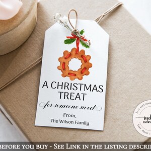 May include: A white gift tag with a red and green Christmas wreath illustration. The text reads "A Christmas Treat for someone sweet. From, The Wilson Family."