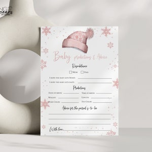 May include: A baby shower game card with a pink winter hat illustration and snowflake accents. The card includes prompts for baby predictions and advice, with sections for resemblance, predictions, and advice for parents-to-be.