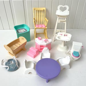 May include: A selection of miniature dollhouse furniture, including a yellow rocking chair with a pink cushion, a crib, a high chair, a sink, a toilet, a table, chairs, and a kitchen set. The pieces are in various colours.