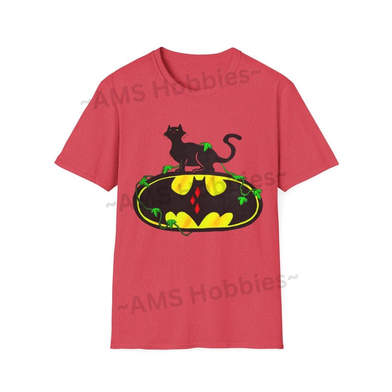 May include: Red t-shirt with a black cat sitting on top of a yellow Batman logo with green vines. The logo has a red diamond in the center.
