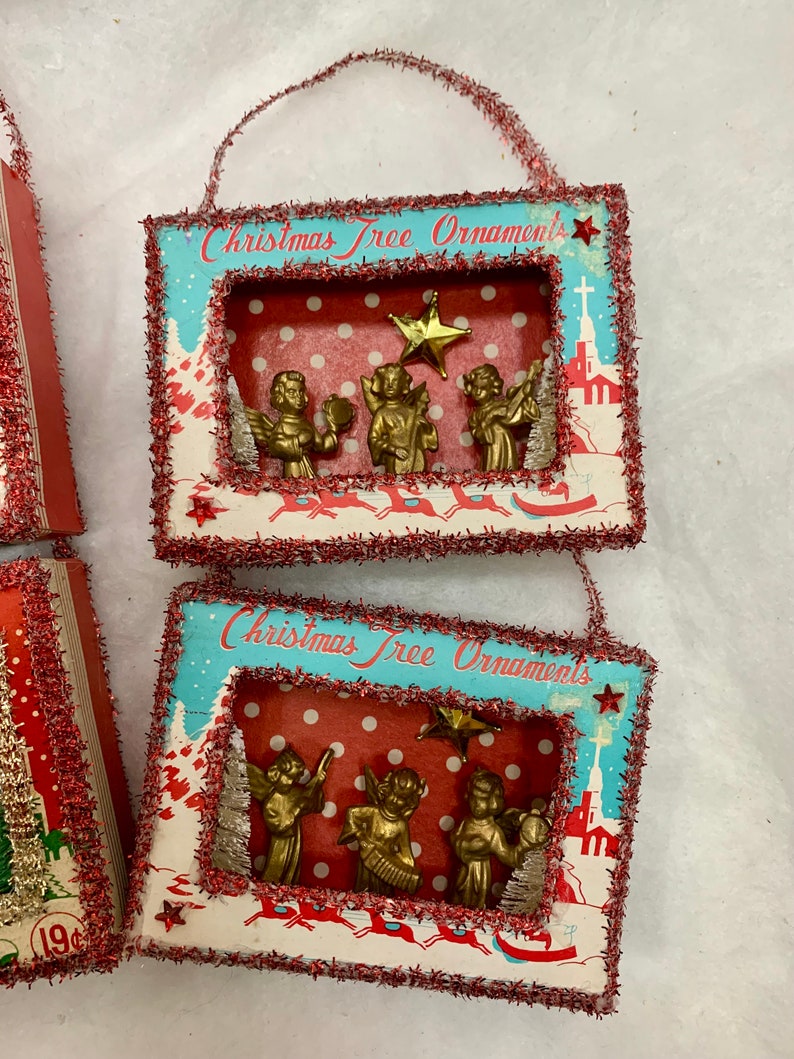 May include: Two vintage Christmas tree ornaments with a red and white polka dot background. Each ornament features a scene with gold angels playing instruments and a star. The ornaments are framed with a red and white border and have the text "Christmas Tree Ornaments" printed on the front.