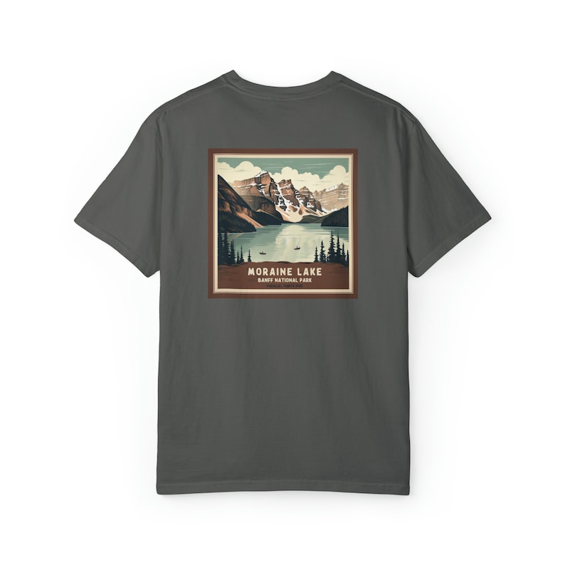 K&ouml;nnte beinhalten: Dunkelgraues T-Shirt mit einem quadratischen Grafikdesign des Moraine Lake im Banff-Nationalpark. Die Grafik zeigt einen See, der von Bergen und B&auml;umen umgeben ist, mit dem Text "Moraine Lake" und "Banff National Park".