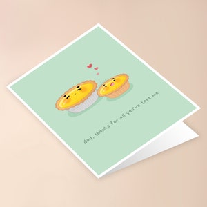 May include: A light green card with two cartoon egg tarts. The larger tart is saying "dad, thanks for all you've tart me". There are three small pink hearts above the tarts.
