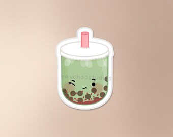 May include: A green bubble tea with tapioca pearls and a pink straw. The tea has a cute cartoon face with a wink and a smile.