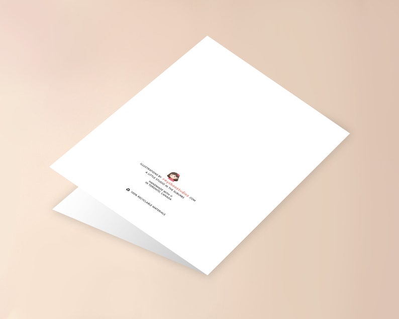 May include: Blank white card with a folded edge. The back of the card has a small illustration of a girl with a red bow and the text "Illustrations by technicolored.com A little studio in the suburbs Handmade with love in Toronto, Canada 100% recyclable materials"