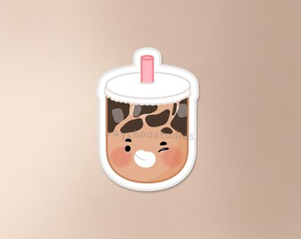 Puede incluir: Una ilustración de dibujos animados de un té de burbujas marrón con una pajita rosa y una tapa blanca. El té de burbujas tiene una cara guiñando un ojo con ojos negros y una sonrisa blanca. El té de burbujas tiene perlas de tapioca marrones en su interior.