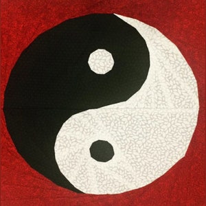 May include: A black and white yin yang symbol on a red background. The yin yang symbol is a circular design with two halves, one black and one white, each containing a smaller circle of the opposite color.