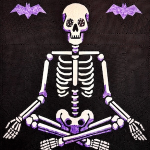 May include: A white skeleton with purple eyes sits in a meditative pose with crossed legs. Two purple bats are flying above the skeleton.