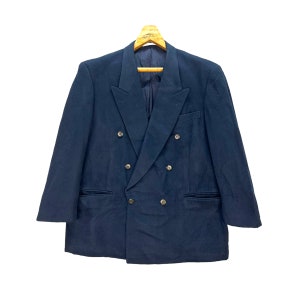 May include: A dark blue double-breasted blazer with a classic design. The blazer has six buttons down the front and two flap pockets.
