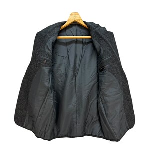 Puede incluir: Una chaqueta de lana gris con forro negro. La chaqueta tiene un cierre de bot&oacute;n &uacute;nico y dos bolsillos en la parte delantera.