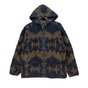 May include: A brown and black patterned fleece jacket with a zipper closure and a hood. The jacket has two zippered pockets on the sides.