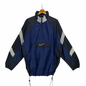 May include: A navy blue, black, and white windbreaker jacket with a zipper closure and a Nike logo on the front.
