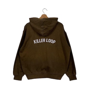 Op de afbeelding: Een bruin hoodie met de tekst "Killer Loop" in wit op de achterkant.