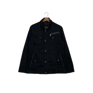 May include: Black jacket with a stand-up collar, button-down front, and multiple pockets. Features a zippered chest pocket and white stitching details. The jacket is hanging on a wooden hanger.