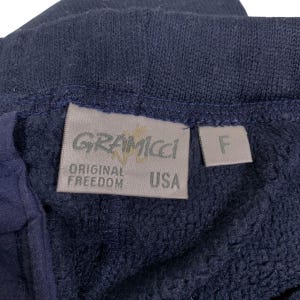May include: A navy blue fleece fabric with a tan label that reads "GRAMICCI ORIGINAL FREEDOM USA" and a smaller tan label that reads "F".