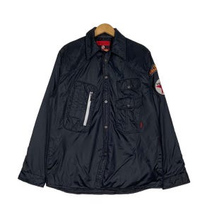 May include: A black quilted button-up shirt jacket with a zippered pocket on the left side and a patch on the right sleeve that says "Texaco".