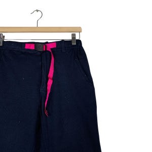 May include: Black pants with a pink belt. The pants have a relaxed fit and are made of a soft, comfortable fabric.