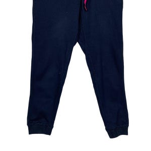 May include: A pair of dark blue sweatpants with a pink drawstring.