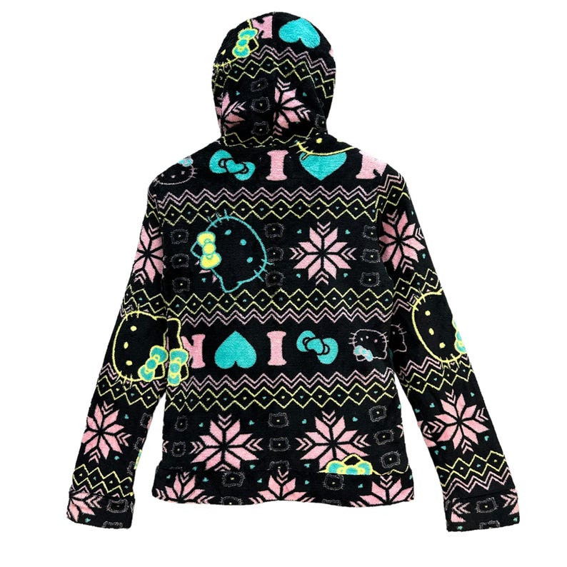 May include: Black fleece hoodie with a colorful pattern featuring Hello Kitty, hearts, and snowflakes. The hoodie has a hood with a drawstring.