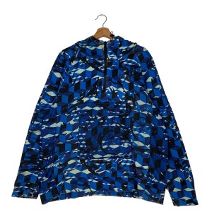 Puede incluir: Una chaqueta azul y negra con capucha y un patrón geométrico. La chaqueta tiene una cremallera de media cremallera y un bolsillo canguro.