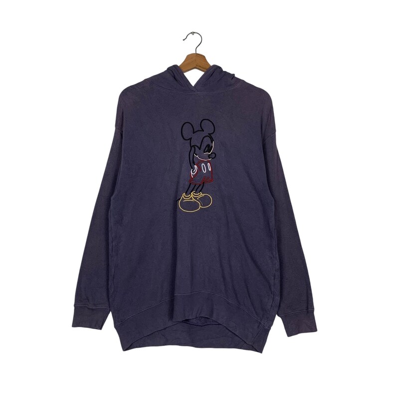 May include: A purple hooded sweatshirt with a Mickey Mouse graphic embroidered on the front. The graphic is in black, red, and yellow.