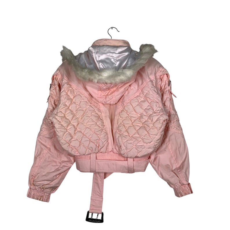 May include: A pink quilted jacket with a white faux fur trim around the hood. The jacket has a belted waist and a zip closure.