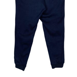May include: A pair of dark blue sweatpants with a cuffed hem.