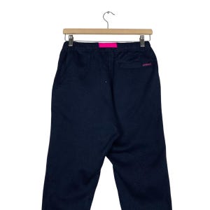 May include: Black sweatpants with a pink waistband and a small logo on the back pocket.