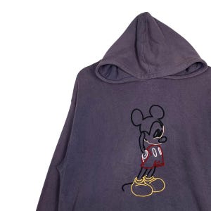 May include: A purple hooded sweatshirt with a black and yellow outline of Mickey Mouse wearing red shorts.
