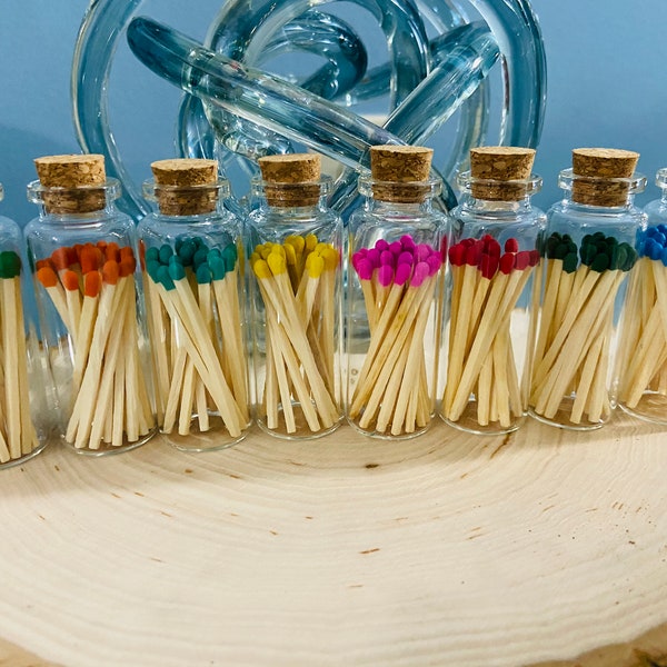 Glass bottles with 20 colored matches and striker on the bottom