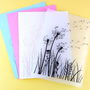 May include: Four sheets of clear plastic with a dandelion design. The top sheet has a black silhouette of dandelions with seeds blowing in the wind. The second sheet has a white embossed dandelion design. The third sheet has a white embossed dandelion design. The bottom sheet has a white embossed dandelion design.