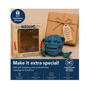 May include: A blue monster toy with green eyes and a wooden box labelled "Boglins" are next to a wrapped gift with a tag. The tag reads "Hope this brings lots of joy and magical memories! Enjoy!" The image also includes text that says "Make it extra special!"