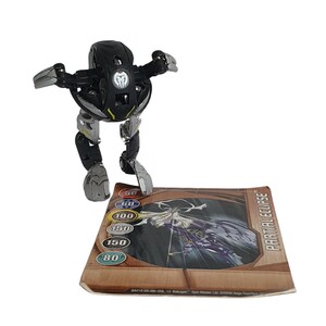 May include: Black and silver Bakugan toy with a card showing a purple and white creature with the text "PARTIAL ECLIPSE". The card has a brown background and shows the Bakugan's stats: 50, 60, 100, 150, 150, and 80.