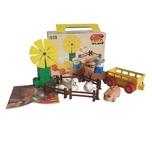 Op de afbeelding: Een vintage Duplo boerderijset met een windmolen, boerderijdieren en een gele wagen. De set bevat een doos met het nummer "1033" en het Duplo-logo. De boerderijdieren zijn onder andere schapen, een varken en kippen.