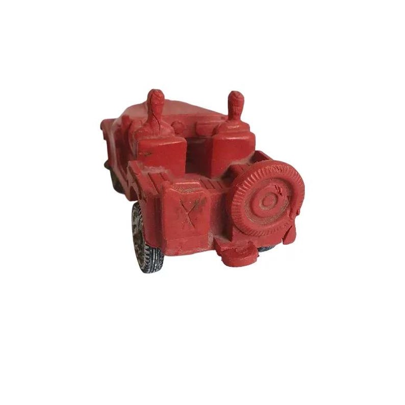 May include: A red toy jeep with two figures in the seats. The jeep has a spare tyre on the back and black tyres.