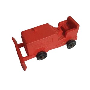 Puede incluir: Un bulldozer de juguete rojo con ruedas negras. El bulldozer tiene una cuchilla levantada en la parte delantera y una cabina detallada.