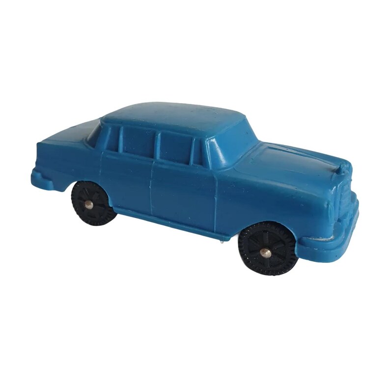 Puede incluir: Un coche de juguete azul con ruedas negras. El sed&aacute;n cl&aacute;sico tiene cuatro puertas, un techo y una parrilla delantera. El coche de juguete es de pl&aacute;stico y es de color azul liso.