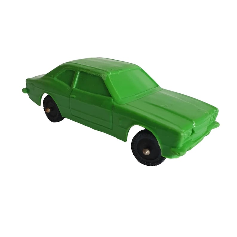 May include: A white ceramic mug with a black handle and the text "But First, Coffee" in a bold, black font. The mug is set against a blurred background, suggesting a cosy setting.