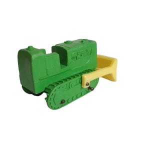 May include: A green toy bulldozer with a yellow blade. The bulldozer has a detailed cab and tracks.