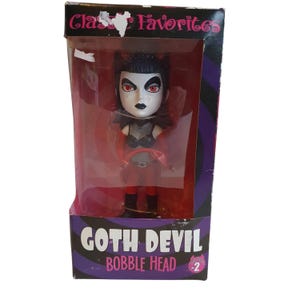 May include: A red and black bobblehead doll of a goth devil with a red tail, black hair, and black wings. The doll is in a clear plastic box with a pink and black background. The box says "Classic Favorites Goth Devil Bobble Head #2".